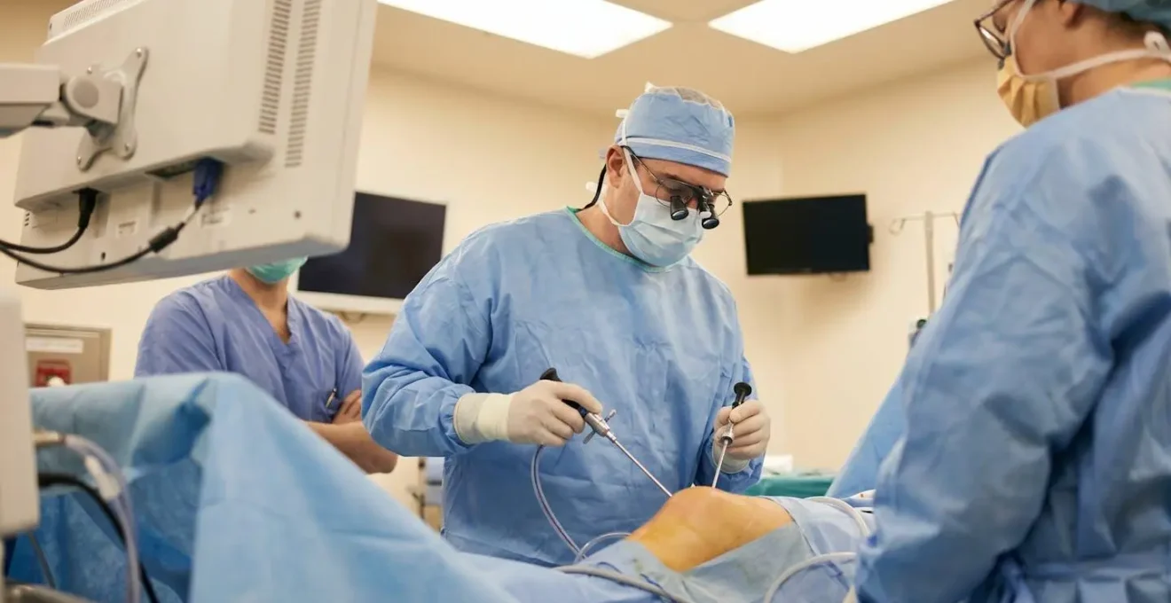 Chirurgien orthopédiste spécialisé genou au bloc opératoire, préparant une intervention de ligamentoplastie
